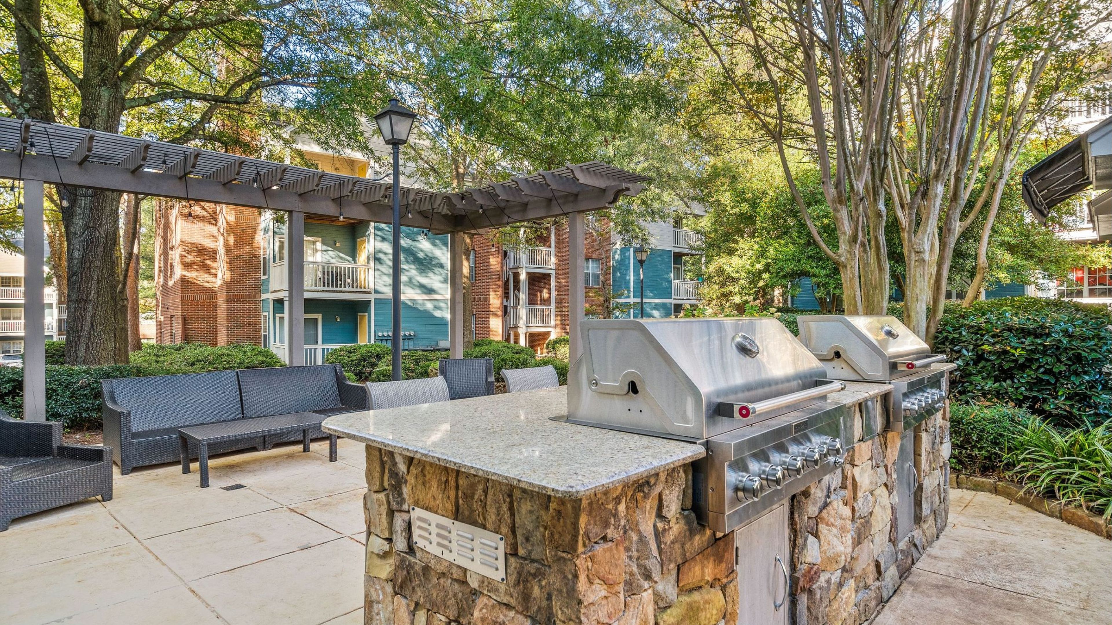 The Haywood outdoor grilling area resident amenity with seating and beautiful stonework.
