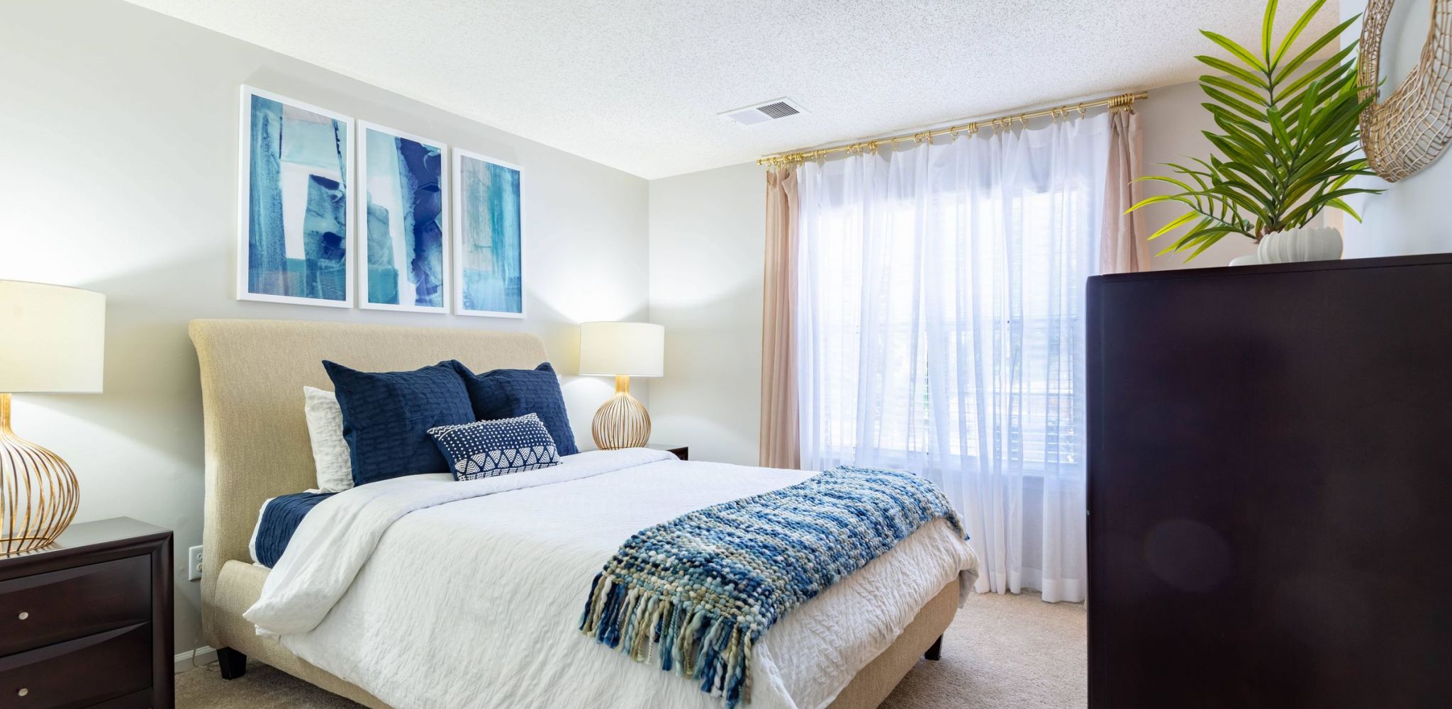 The Haywood apartment bedroom with large window and carpet floor.
